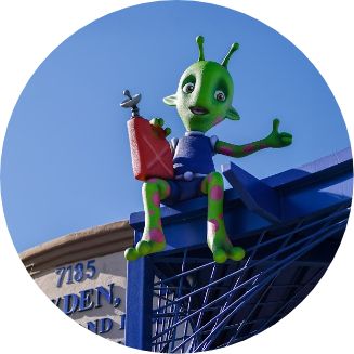 Figure of a green alien giving a thumbs up on the roof of a pediatric dental office in El Paso